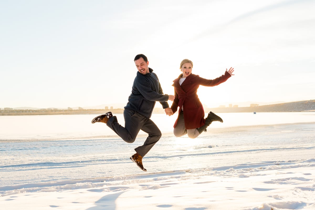 cherry creek state park engagement photos, a couple jumps in the snow. 