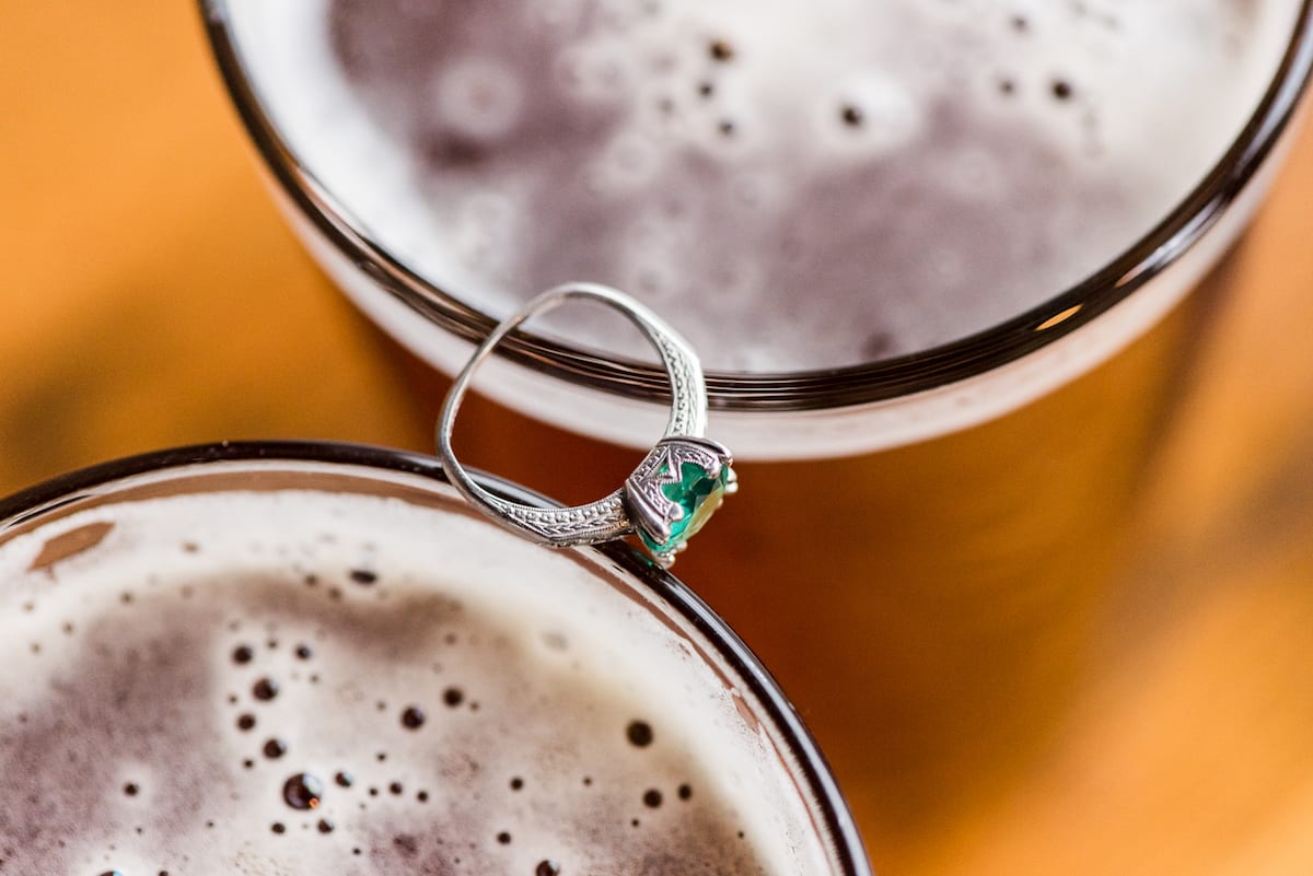 Engagement ring closeup with two beers