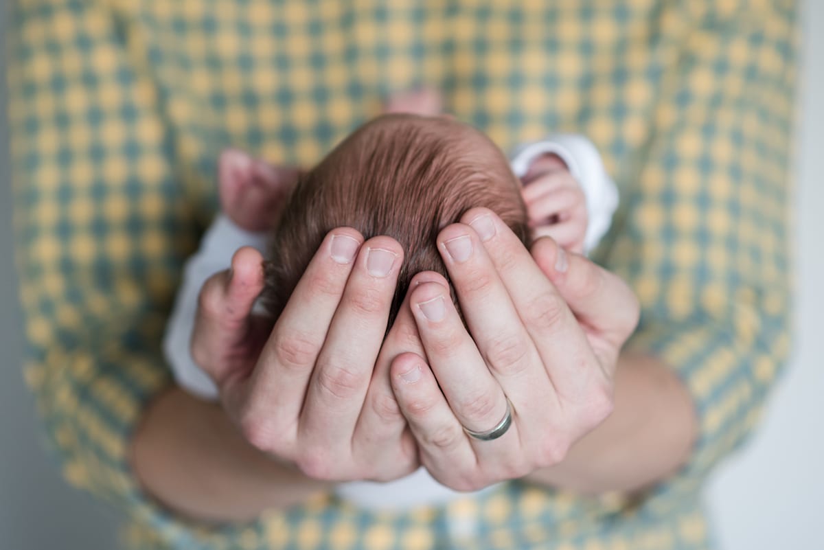 Father holds newborn close up of hands