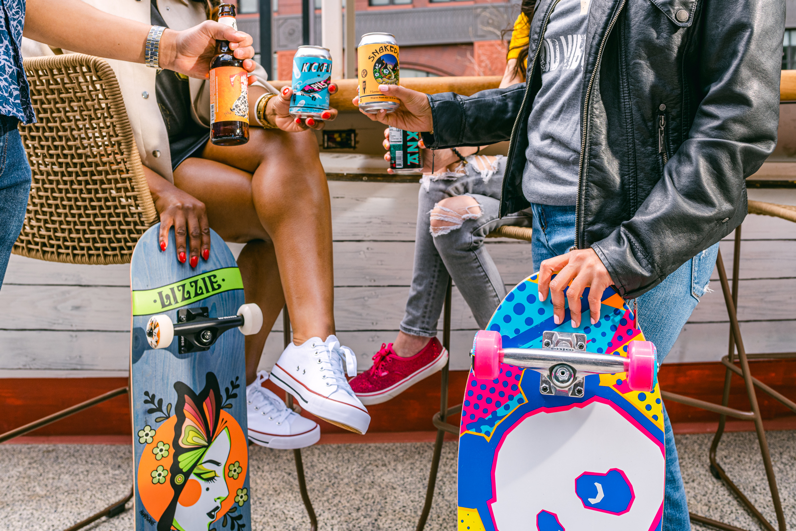 Four people toast their drinks while two of them hold up skateboards | Bethesda, MD | Oceanside, CA