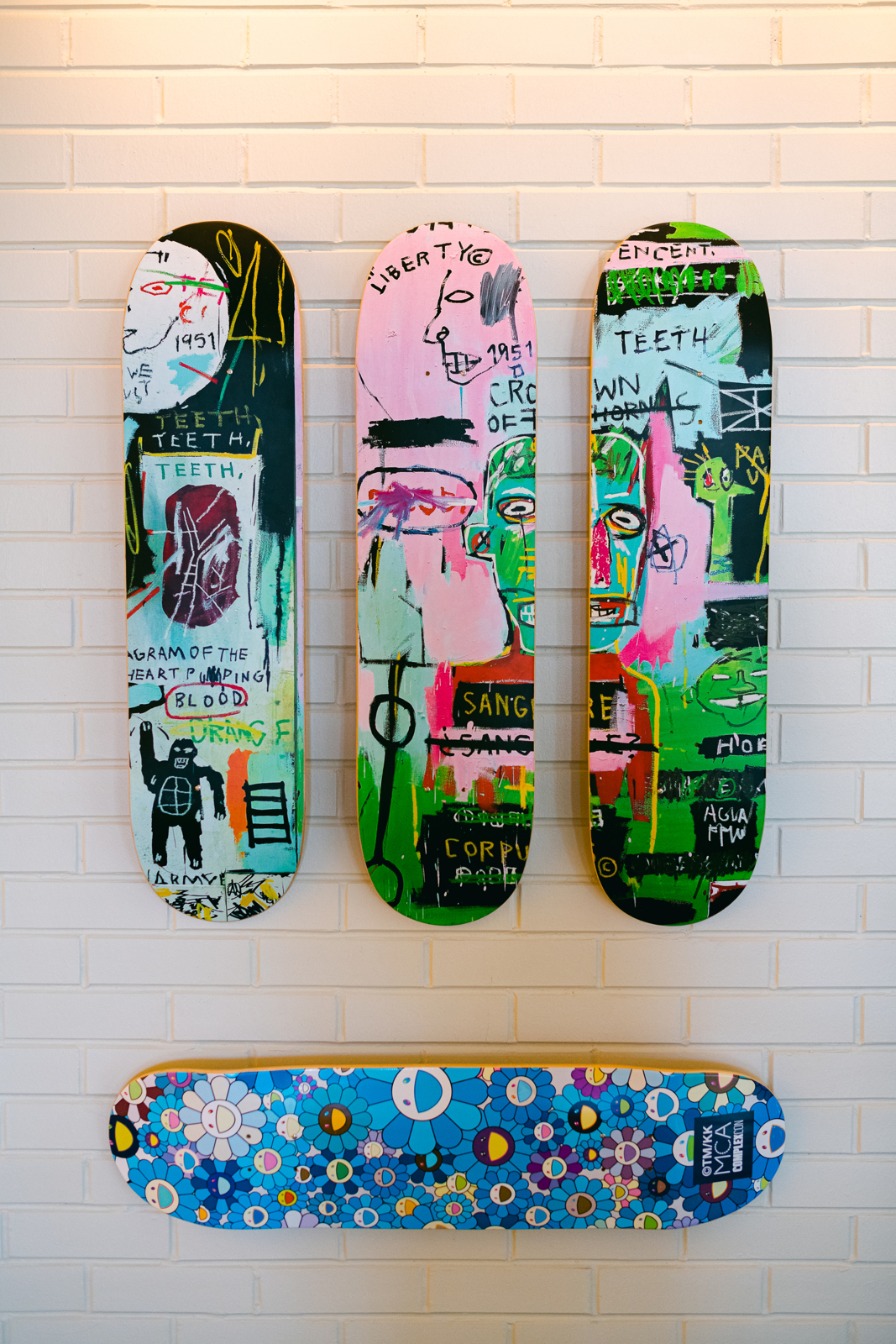 Product Photography | Four colorful skateboards hanging from white brick wall | Bethesda, MD | Oceanside, CA