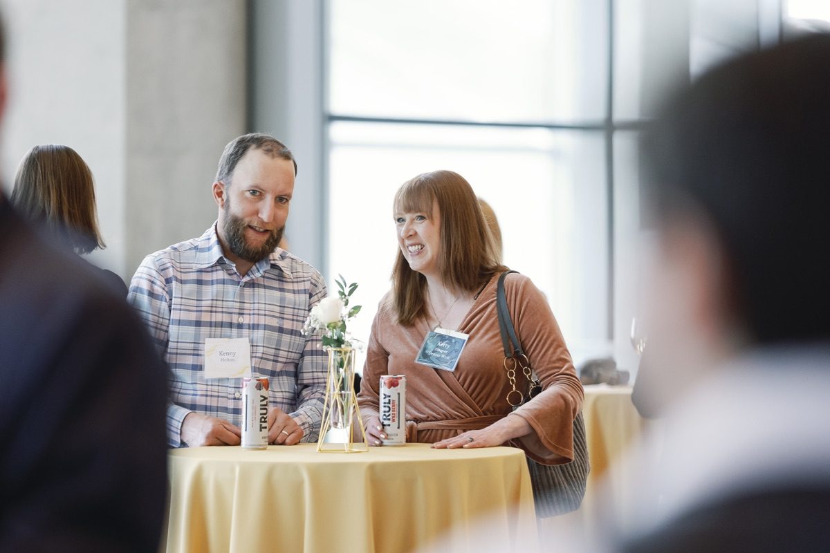 Two attendees laughing at networking cocktail table
