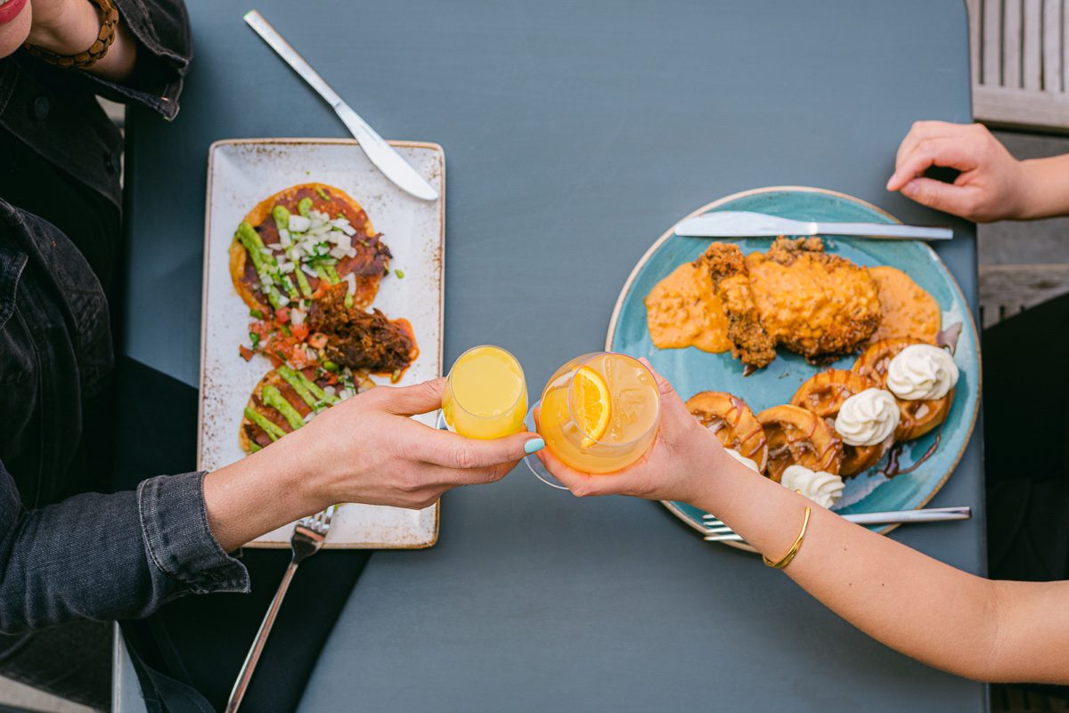 Overhead of two people toasting cocktails
