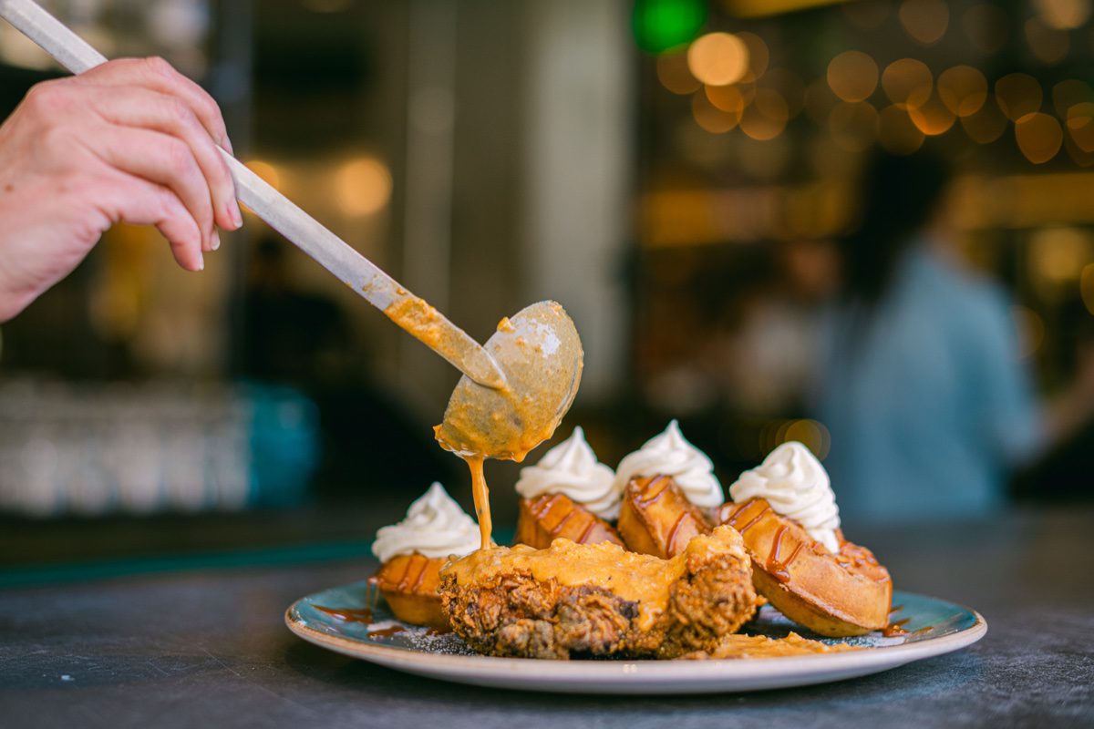 Honey spooned over fried chicken and cream puff platter