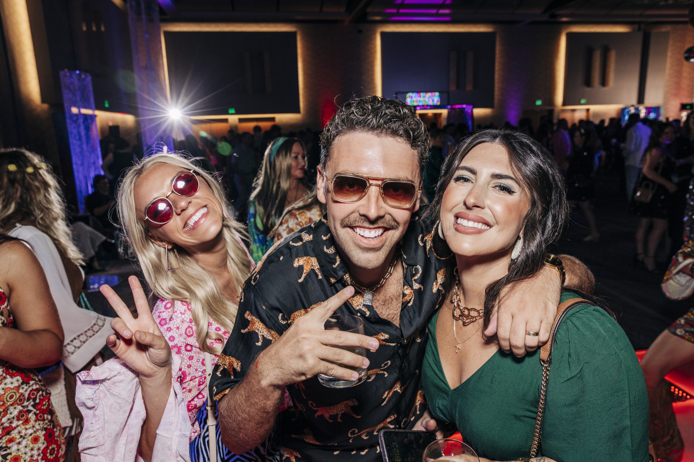 High-energy party candid -- guests posing under the stage lights