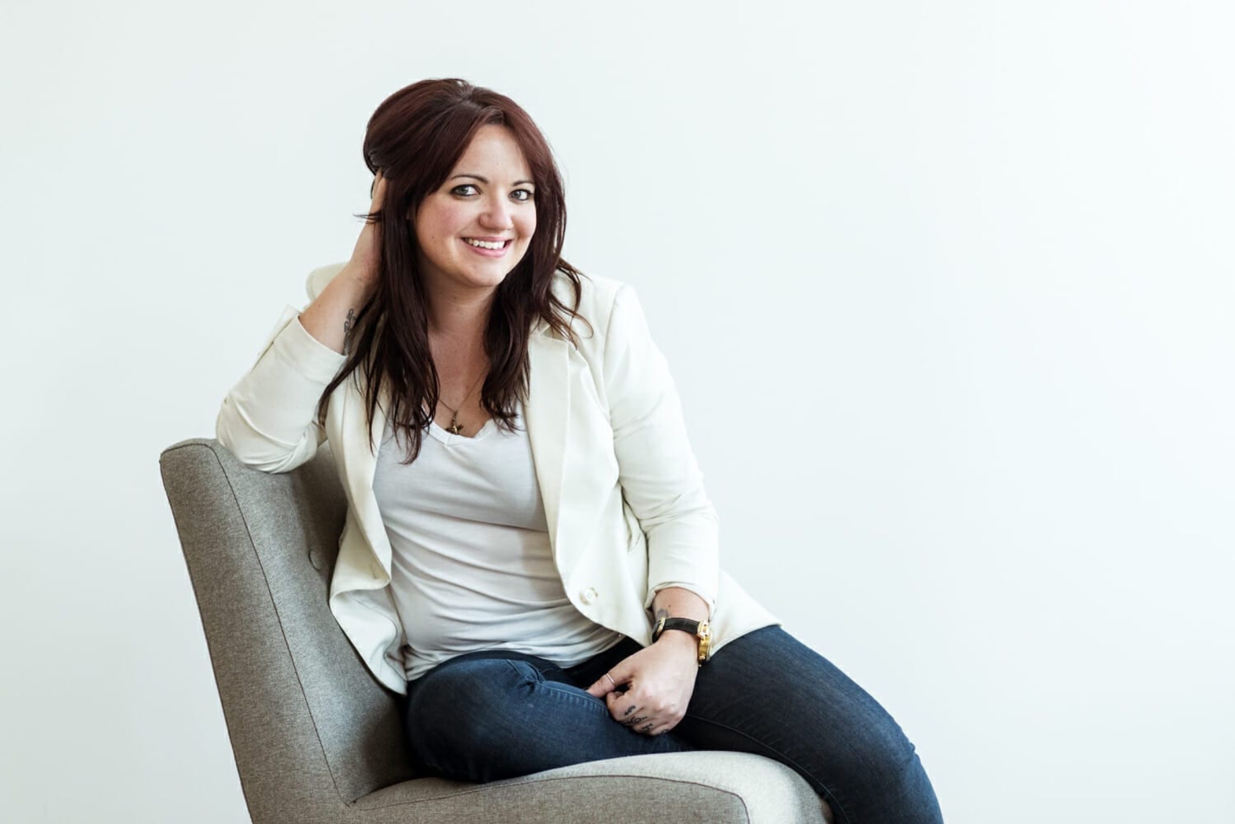 Warm grounded studio chair -- approachable, not stiff, real smile