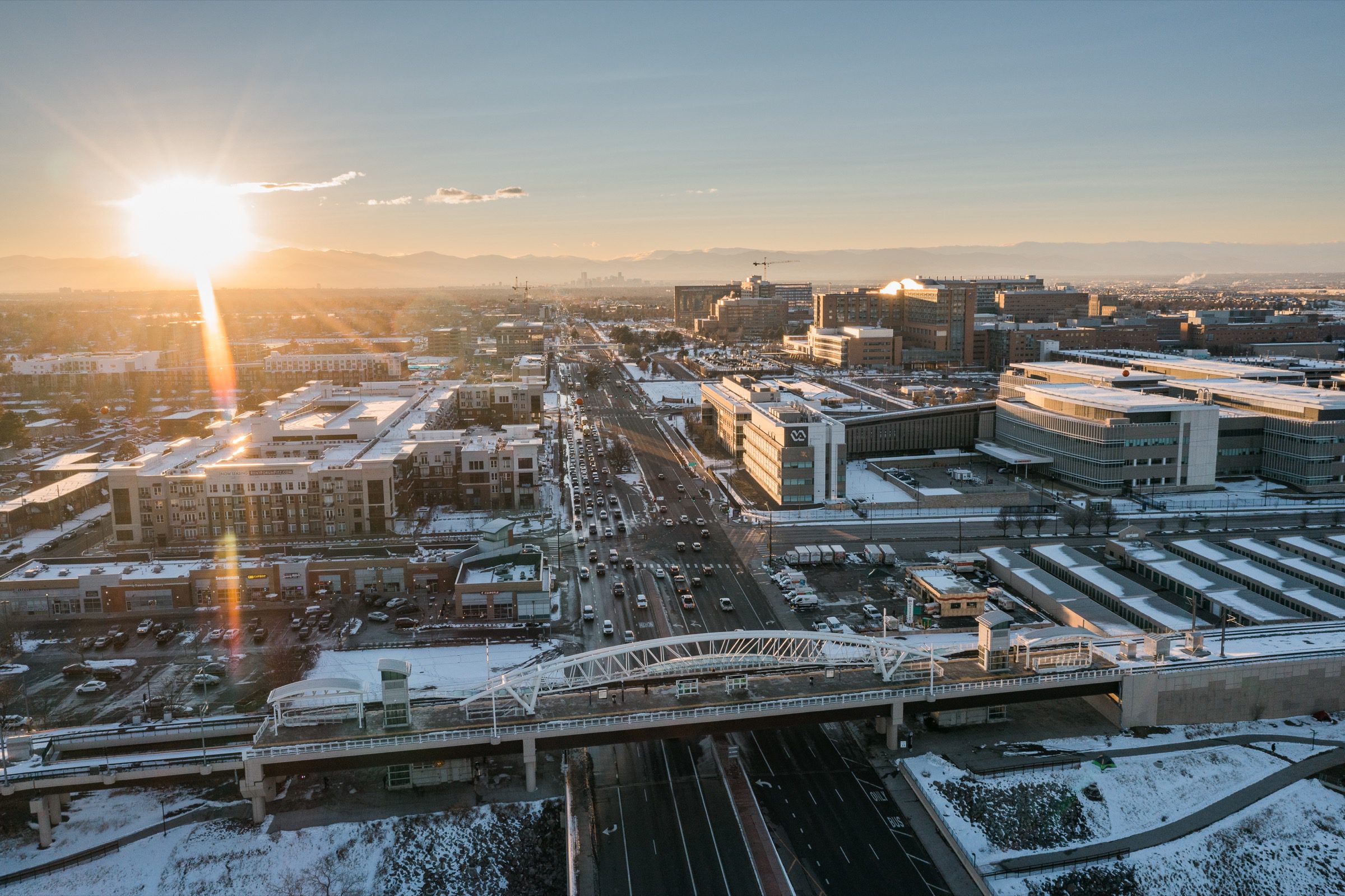 Golden hour aerial of city with bridge and mountain views