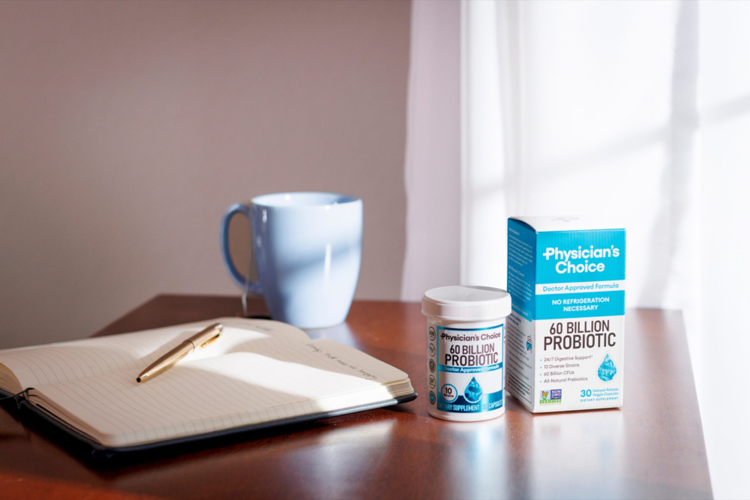 Morning-routine lifestyle frame -- journal, mug, and product in soft window light