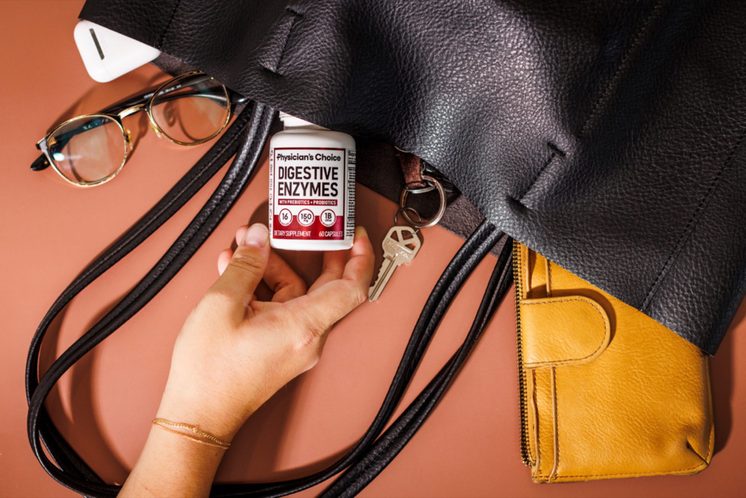 Hand-and-product flat lay -- the human, on-the-go beat for lifestyle and Reels