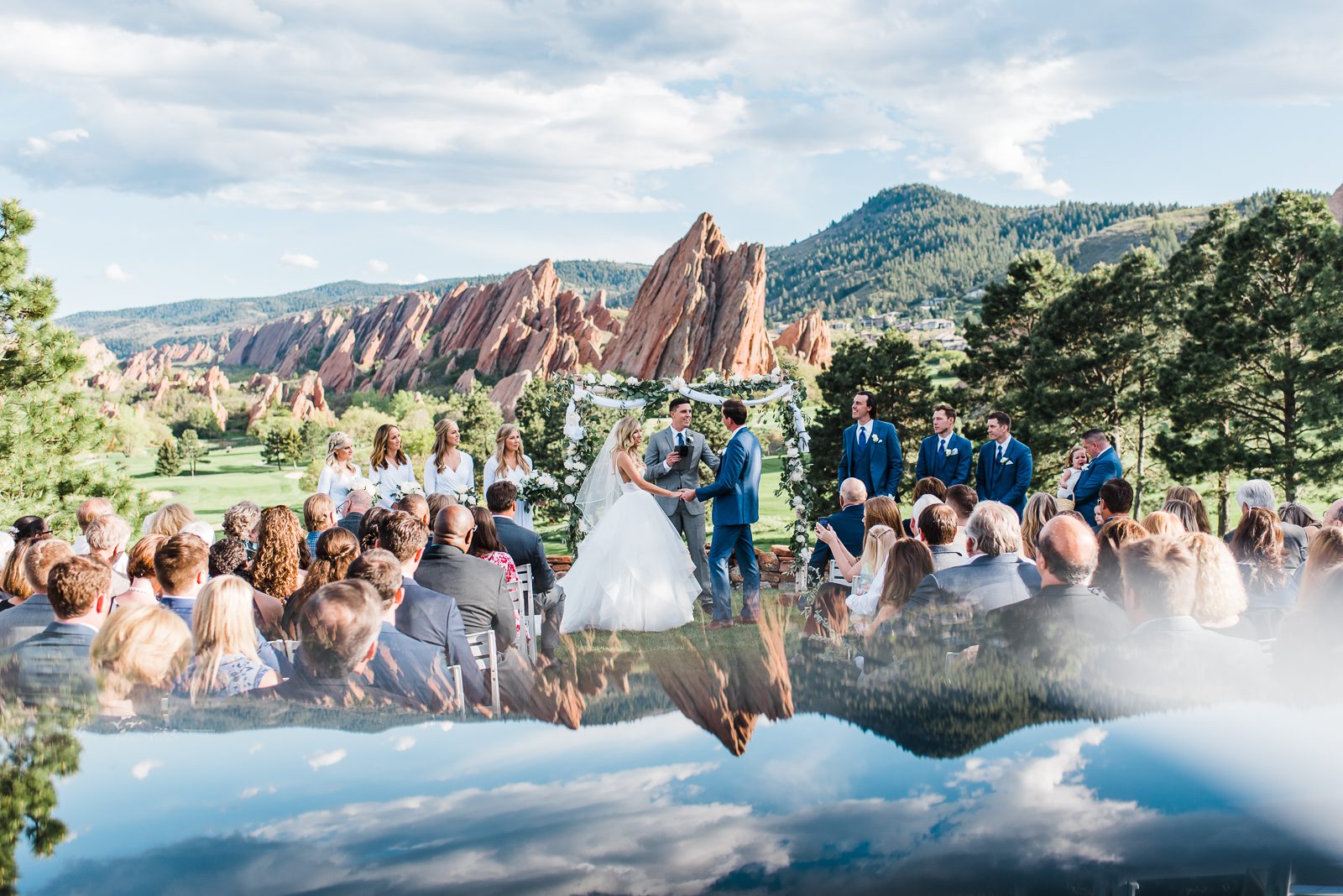 Wedding ceremony on the lawn at Arrowhead Golf Club with the red sandstone formations behind