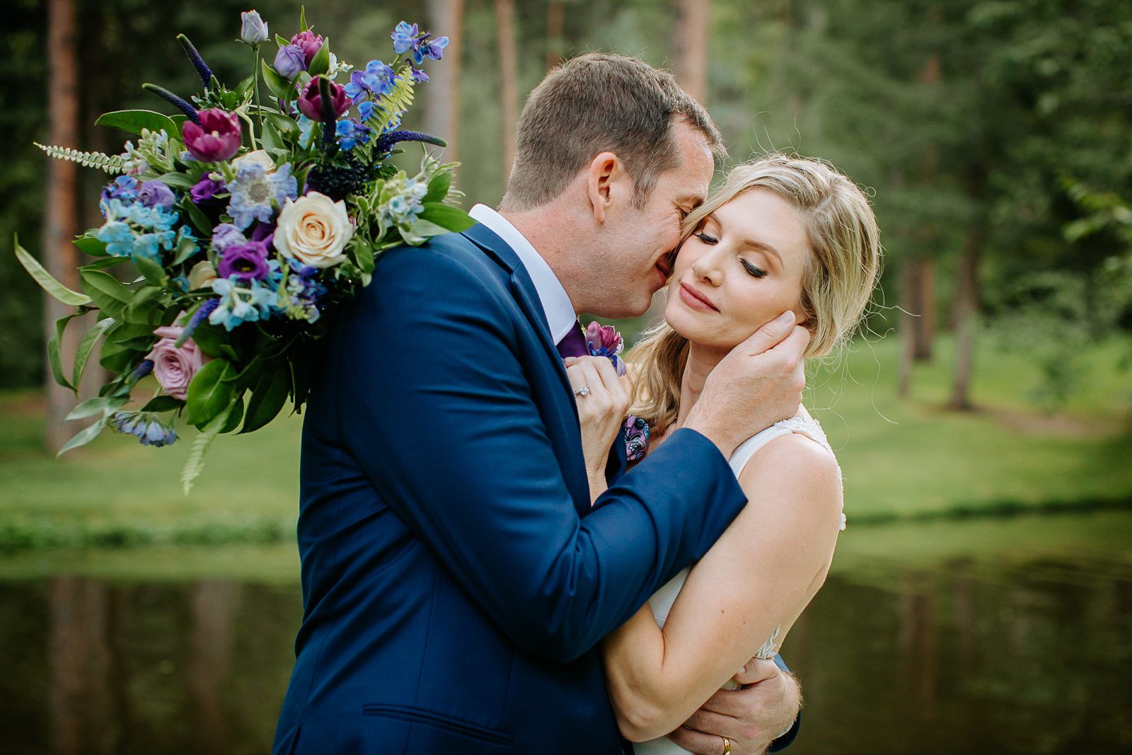 Bride and groom close together with a wildflower bouquet at Arrowhead Golf Club