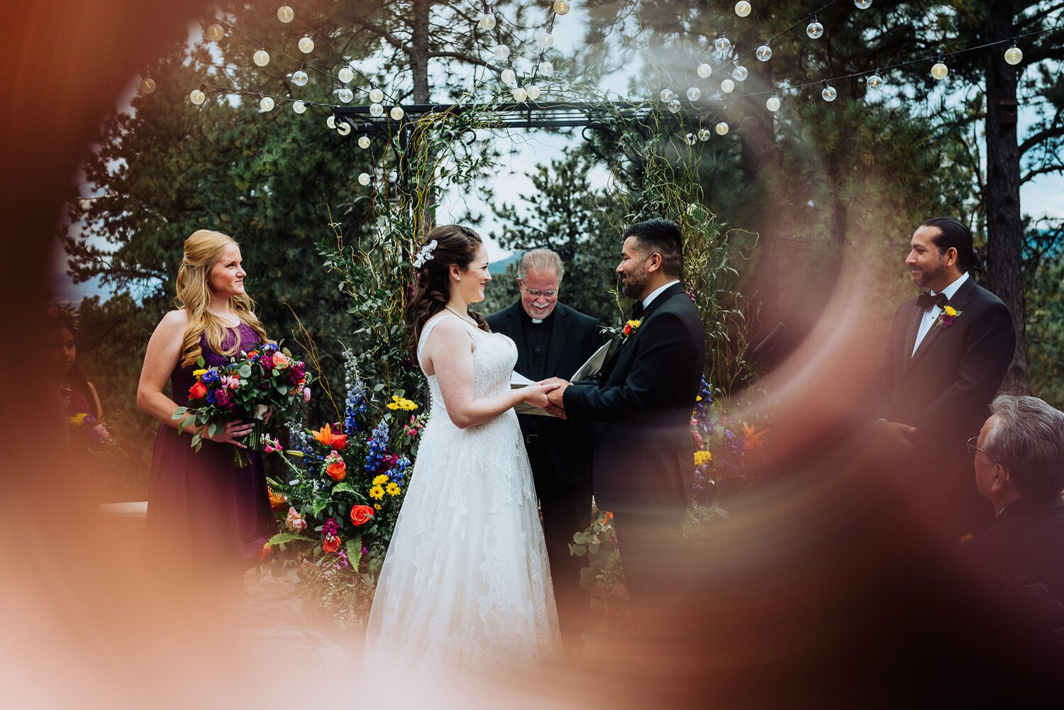 Wedding ceremony beneath a wildflower arch at Boettcher Mansion