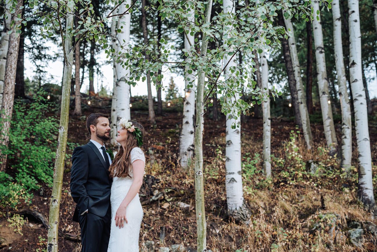 Bride and groom among the aspens with string lights at Blackstone Rivers Ranch