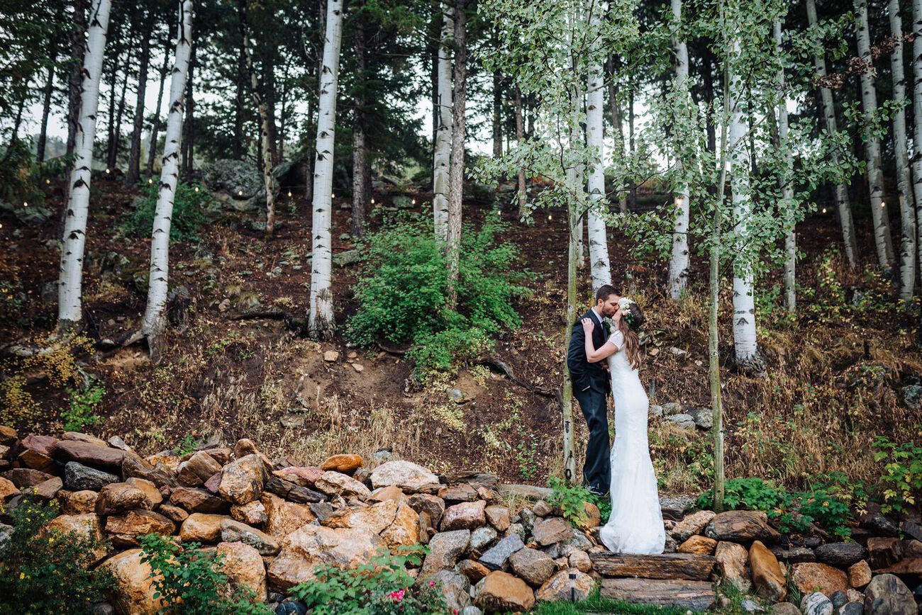 Bride and groom embracing on the stone steps in the aspens at Blackstone Rivers Ranch
