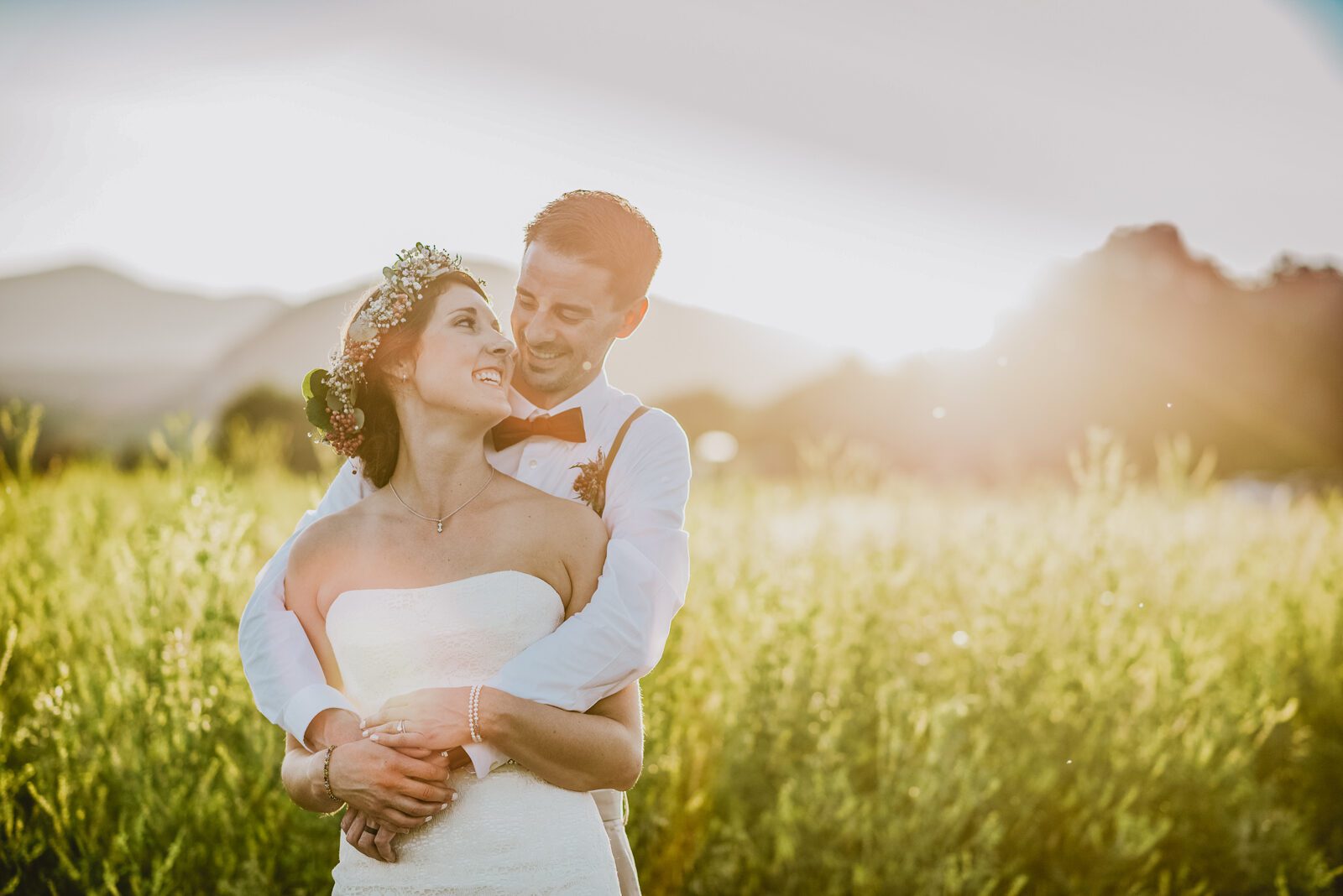 Bride and groom in the golden meadow at sunset with the foothills behind them at Denver Botanic Gardens Chatfield Farms