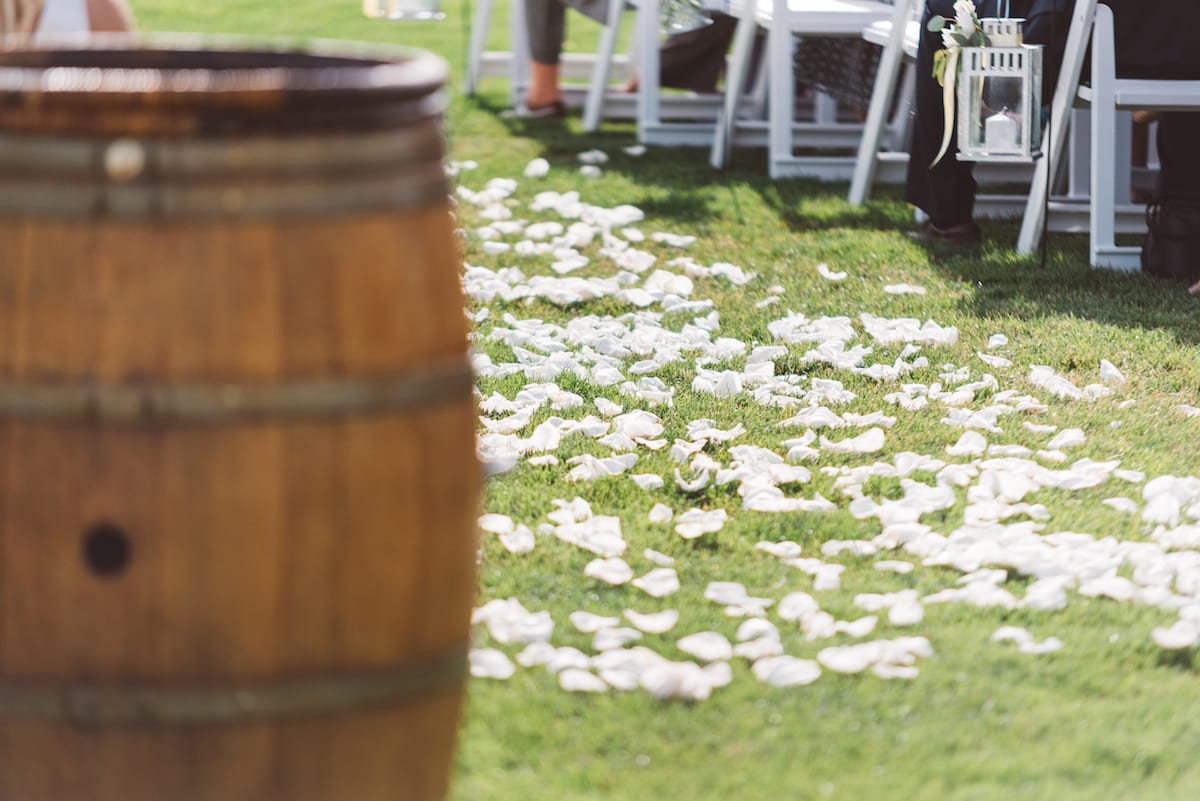 Wine barrel and petal-strewn aisle before a ceremony at Crooked Willow Farms
