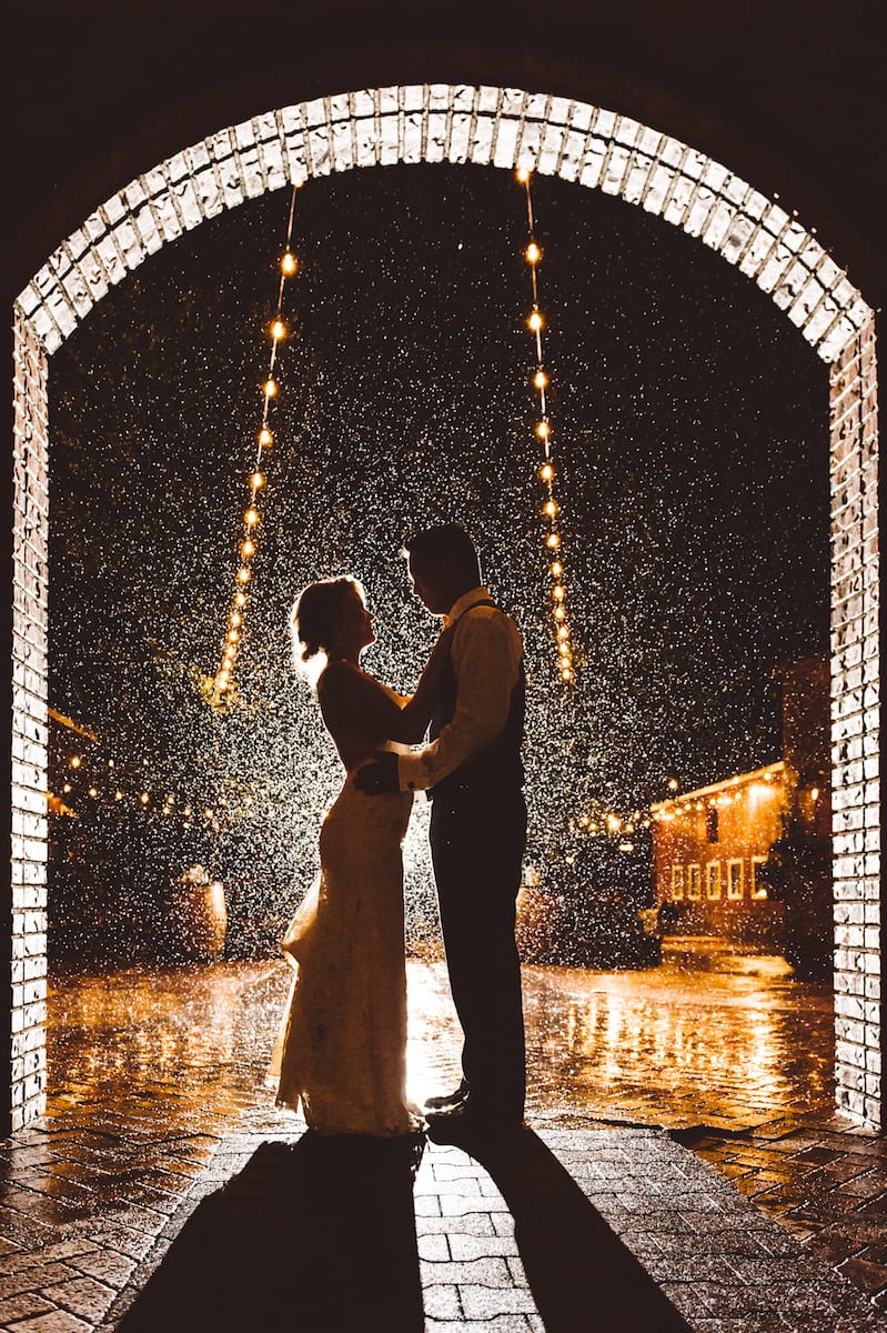 A couple beneath string lights at night at Crooked Willow Farms