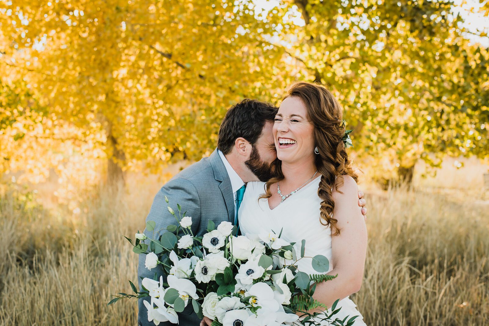 Bride and groom in the golden autumn grasses of City Park, Denver