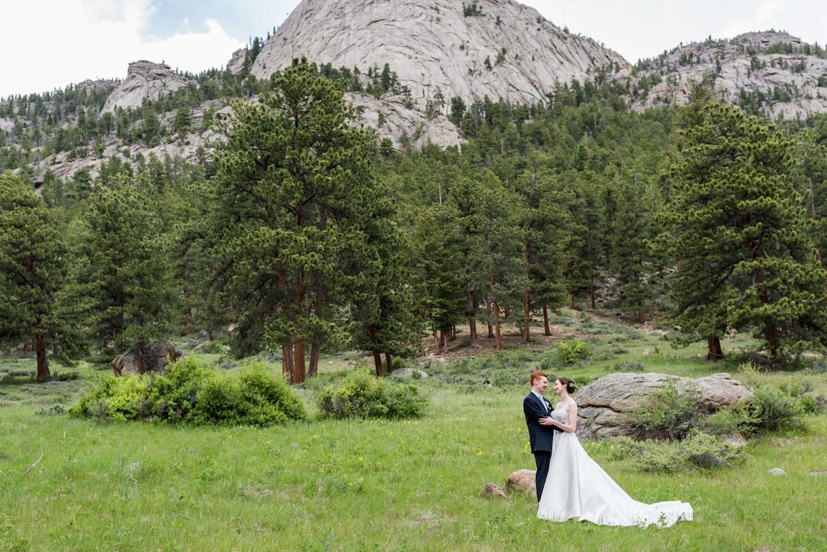 Bride and groom in the meadow below the rock formations at Della Terra Mountain Chateau