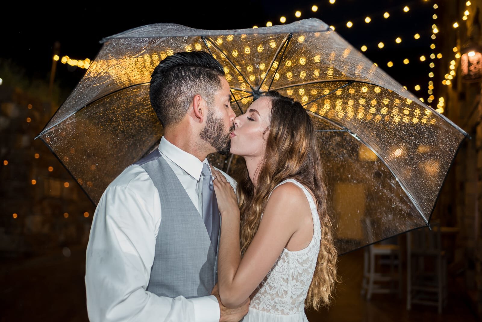 Couple under a clear umbrella beneath string lights at Della Terra Mountain Chateau