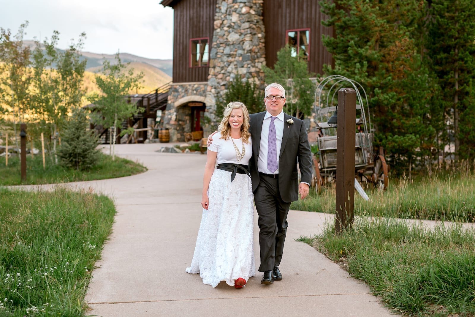 Bride walking the path to the ceremony with her father at Devil's Thumb Ranch
