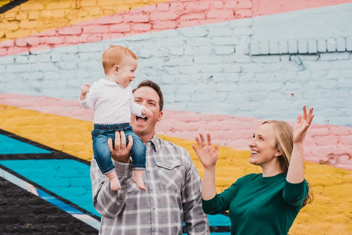 Family with a baby in front of a colorful RiNo Art District mural in Denver