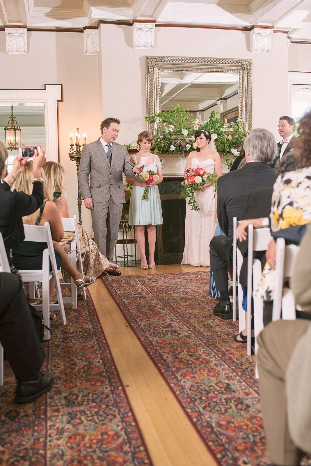 Indoor wedding ceremony down the patterned aisle runner inside the Grant-Humphreys Mansion