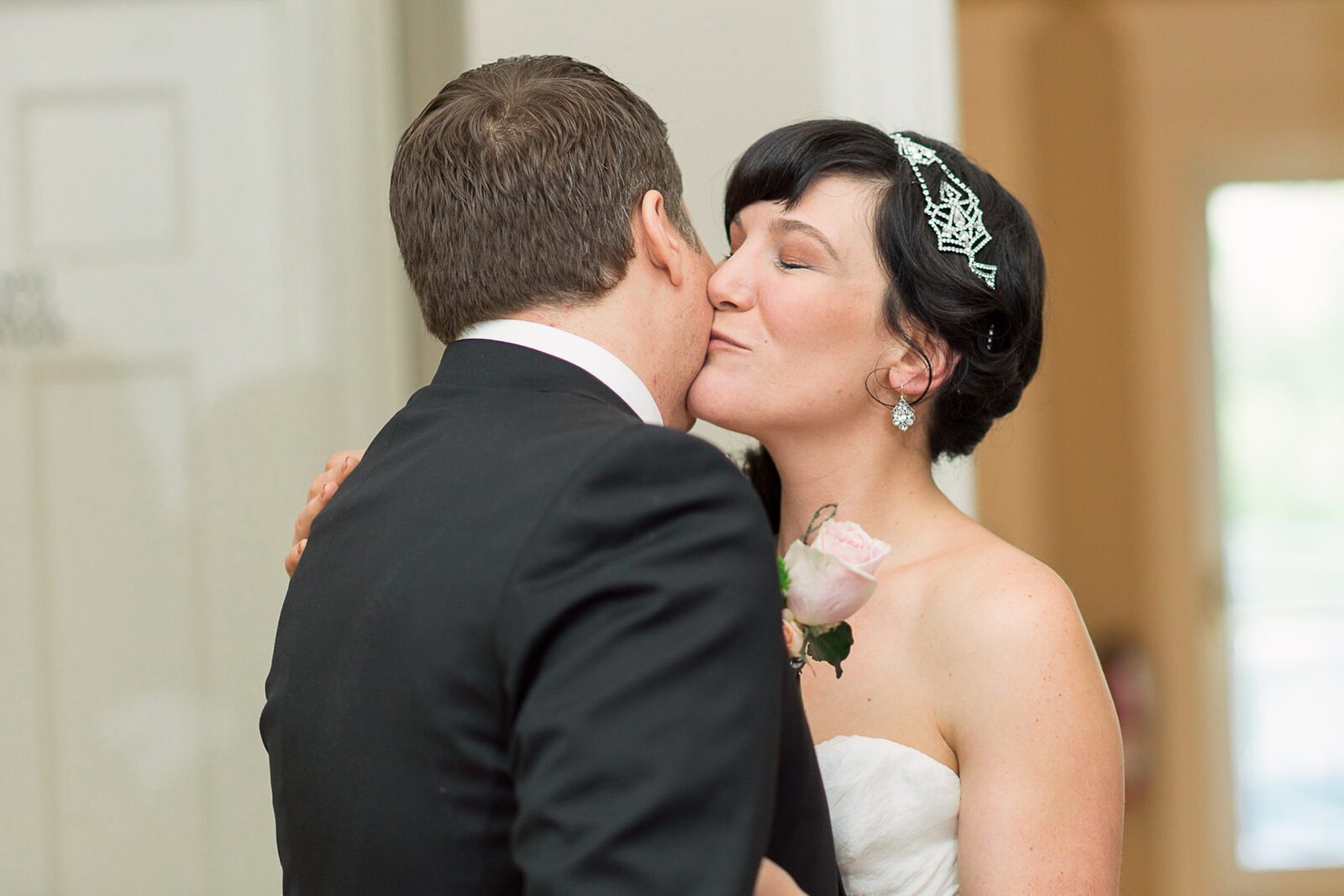 Newlyweds sharing a first kiss at their Grant-Humphreys Mansion wedding