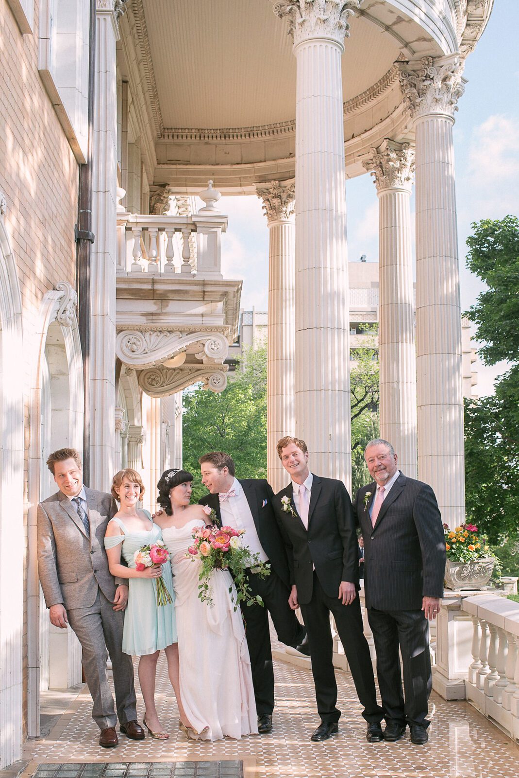 Wedding party gathered along the colonnade at the Grant-Humphreys Mansion in Denver