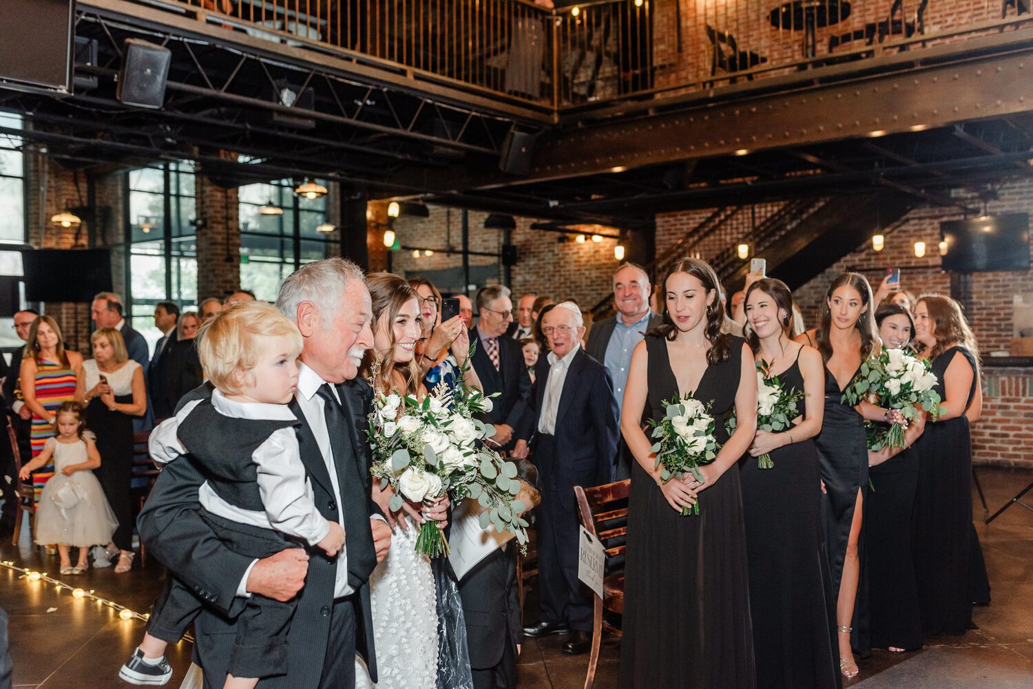 The wedding party gathered under the industrial ceiling at Mile High Station