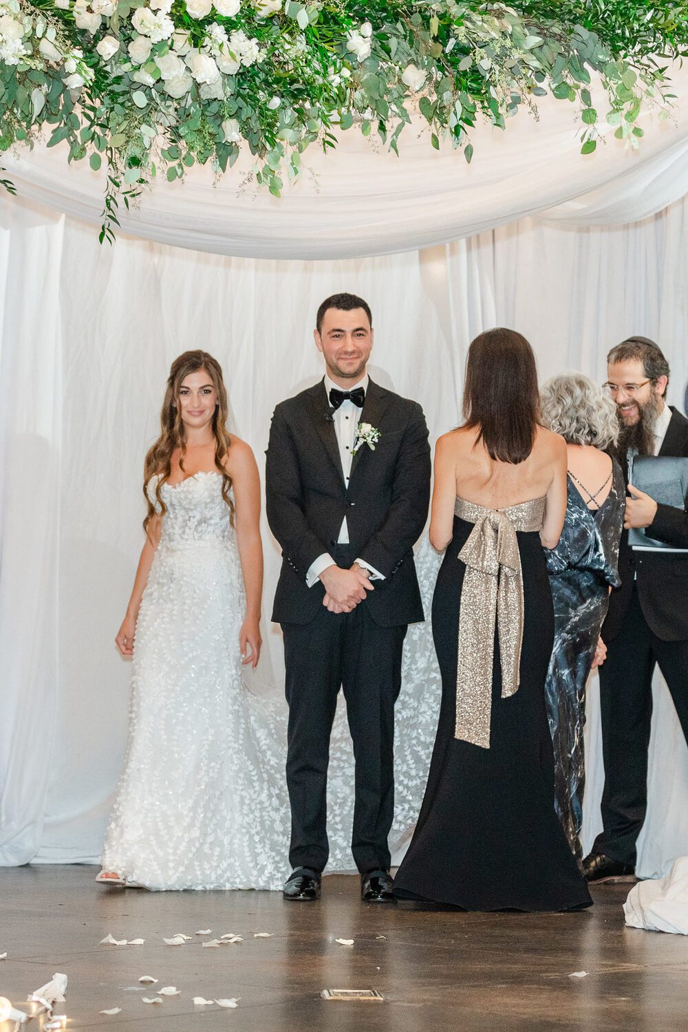 The couple with family beneath the draped chuppah at Mile High Station