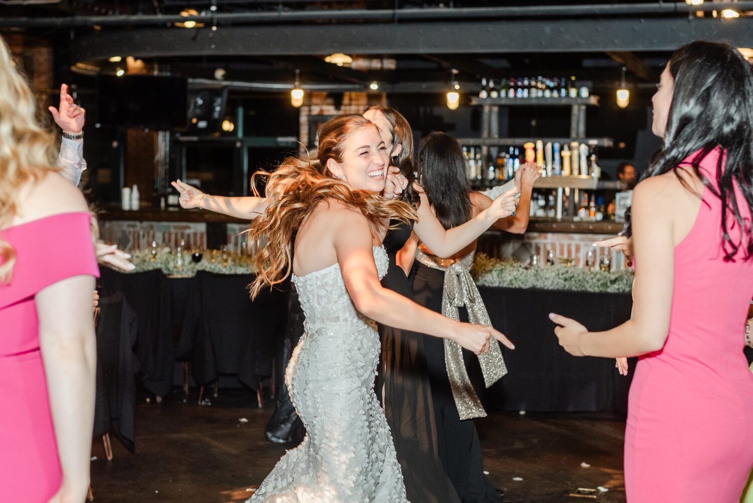 Guests dancing together in front of the bar at a Mile High Station reception