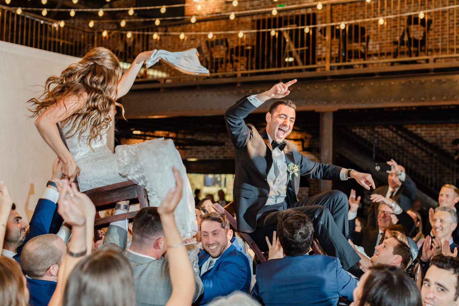 Guests lifting the couple during the hora at Mile High Station, the mezzanine above