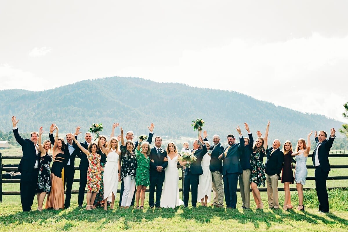 Wedding party cheering in the meadow at Spruce Mountain Ranch