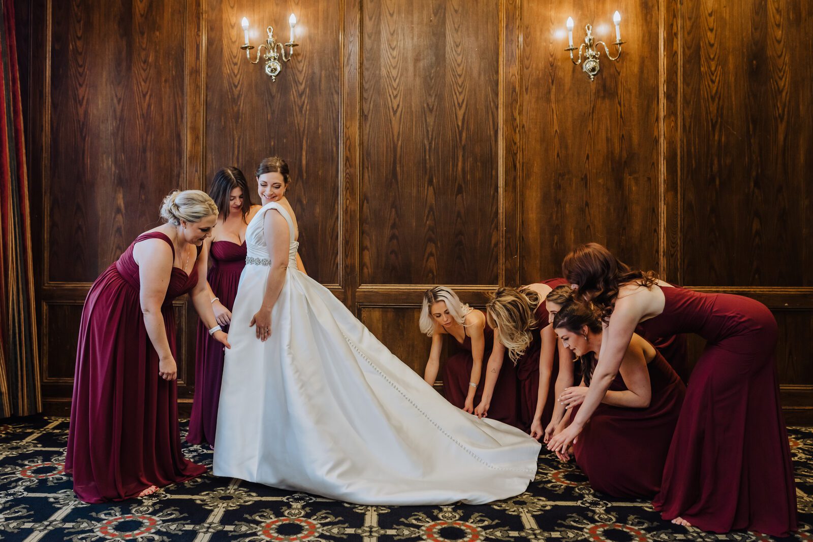 Bridesmaids arranging the bride's train in a wood-panelled room at the Denver Athletic Club
