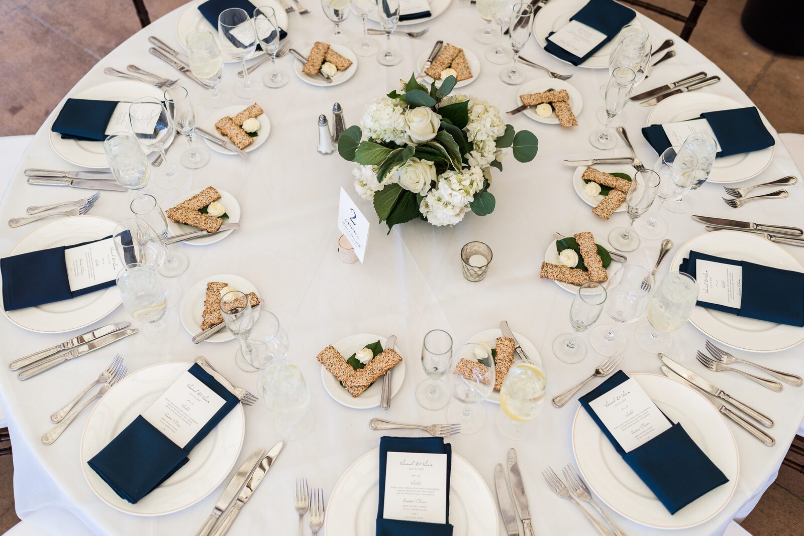 Overhead view of a reception table at the Denver Athletic Club, navy linens and gold place settings